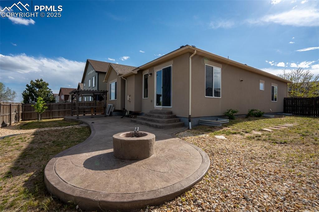 Backyard with stamped concrete, pergola, and fire pit