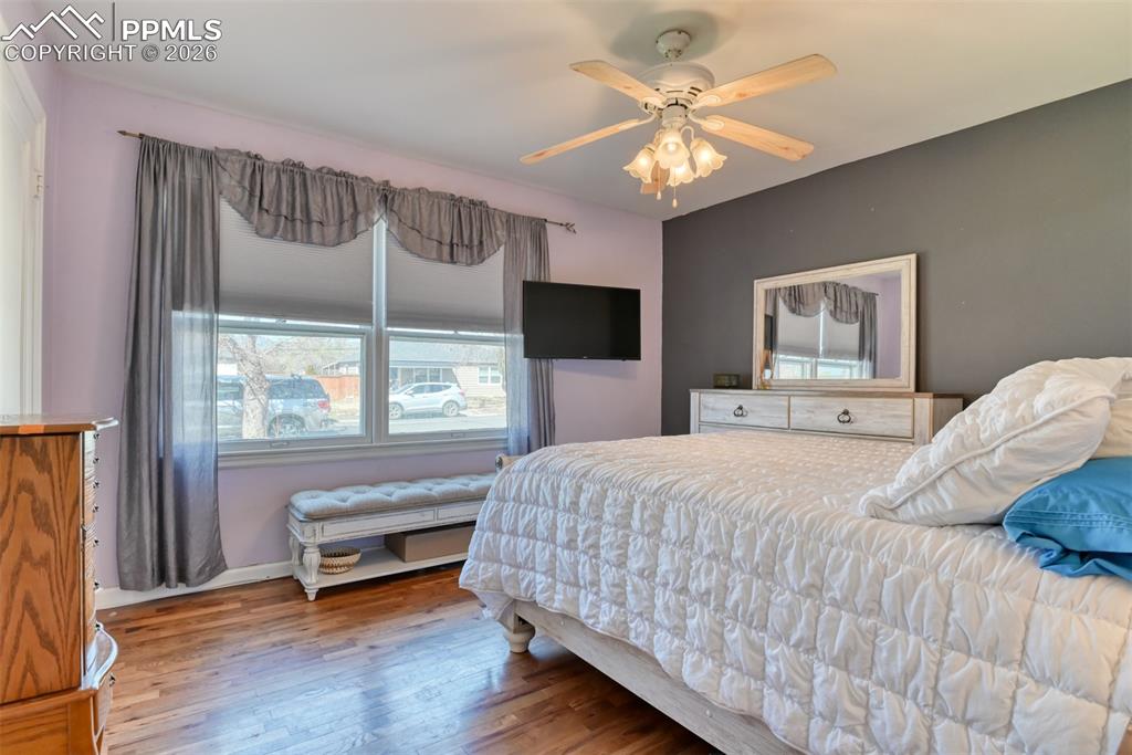 Bedroom with ceiling fan, wood finished floors, and baseboards