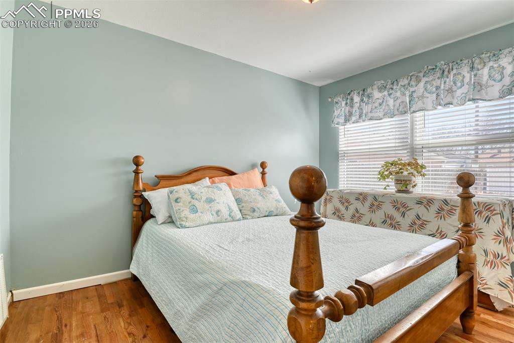 Bedroom with wood finished floors and baseboards