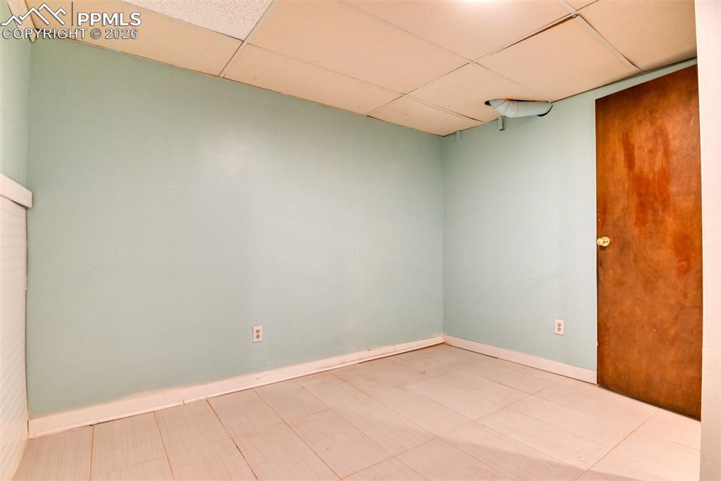 Unfurnished room featuring baseboards and a paneled ceiling