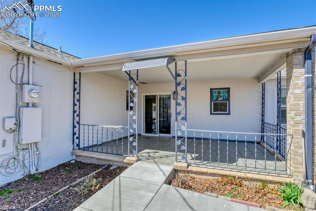 View of exterior entry with a patio area and stucco siding