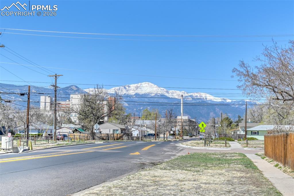 View of street featuring traffic signs, sidewalks, a mountain view, and a residential view