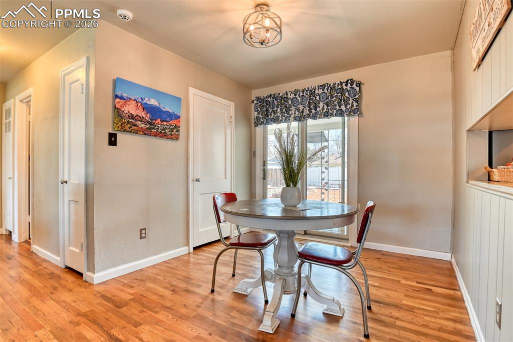 Dining room featuring light wood-style flooring, an inviting chandelier, and baseboards