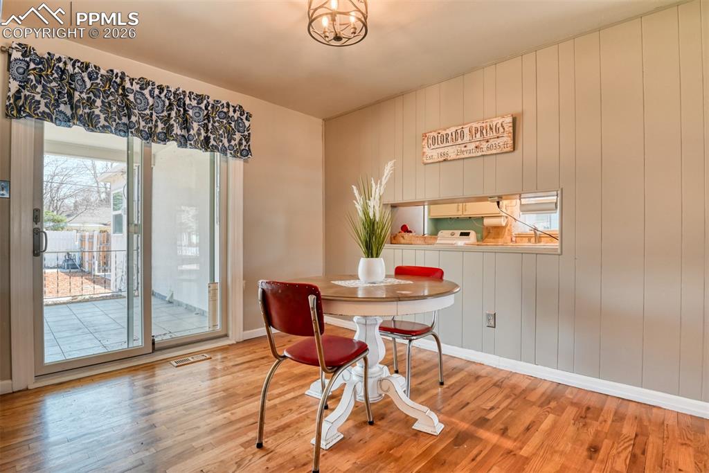 Dining space with wood finished floors, baseboards, and visible vents