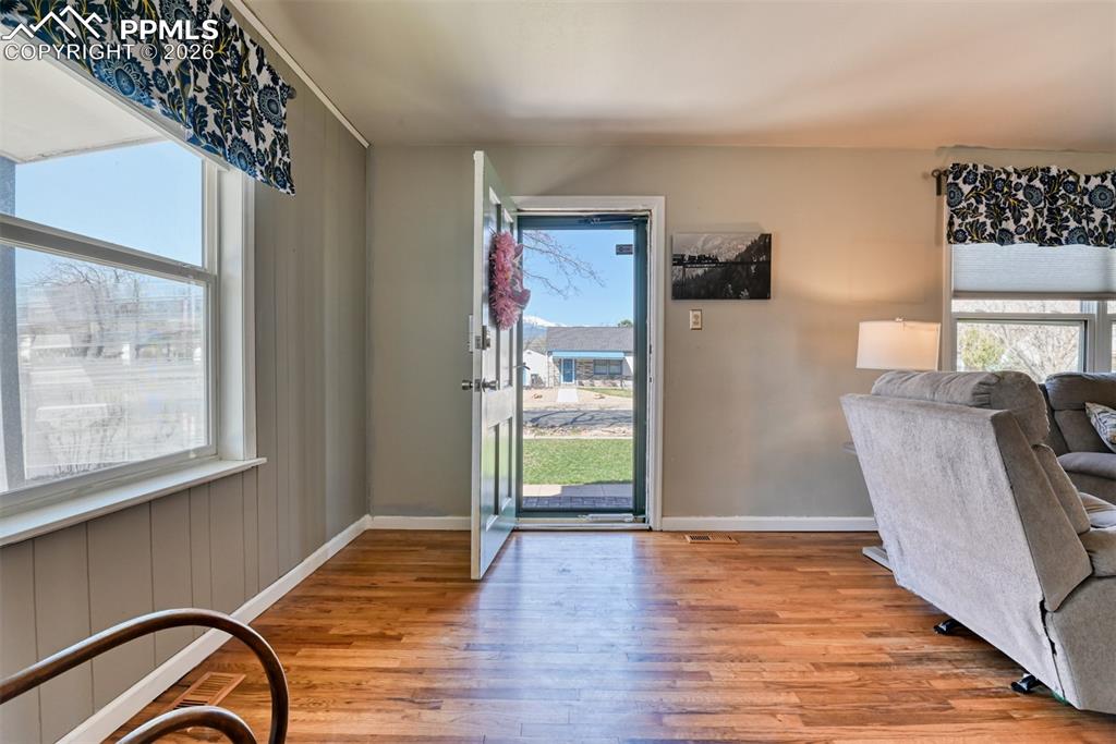 Doorway with baseboards and wood finished floors