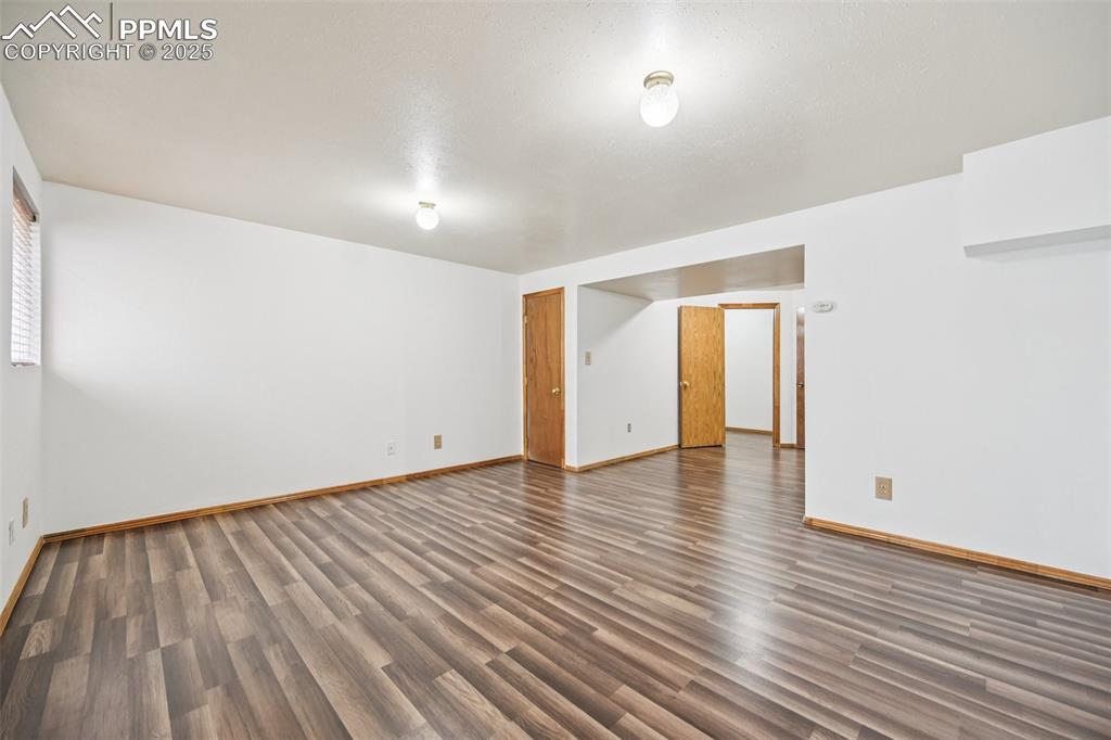 Spare room featuring dark wood-type flooring
