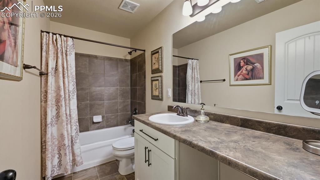 Upper Level Full Bathroom with vanity, mirror, and tiled tub/shower.
