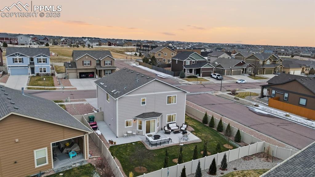 Aerial rear view of home and fenced backyard.