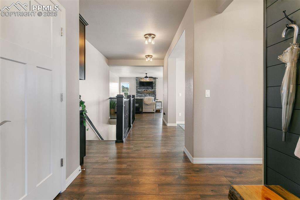 Hallway with dark wood finished floors and an upstairs landing