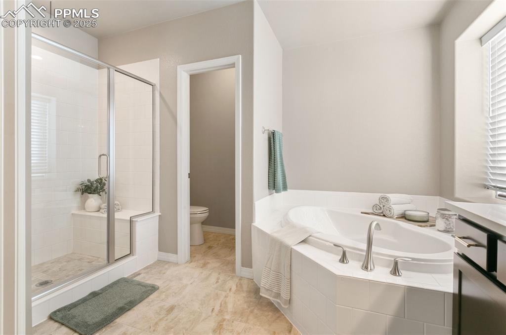 Bathroom featuring a stall shower, a bath, and light tile patterned floors