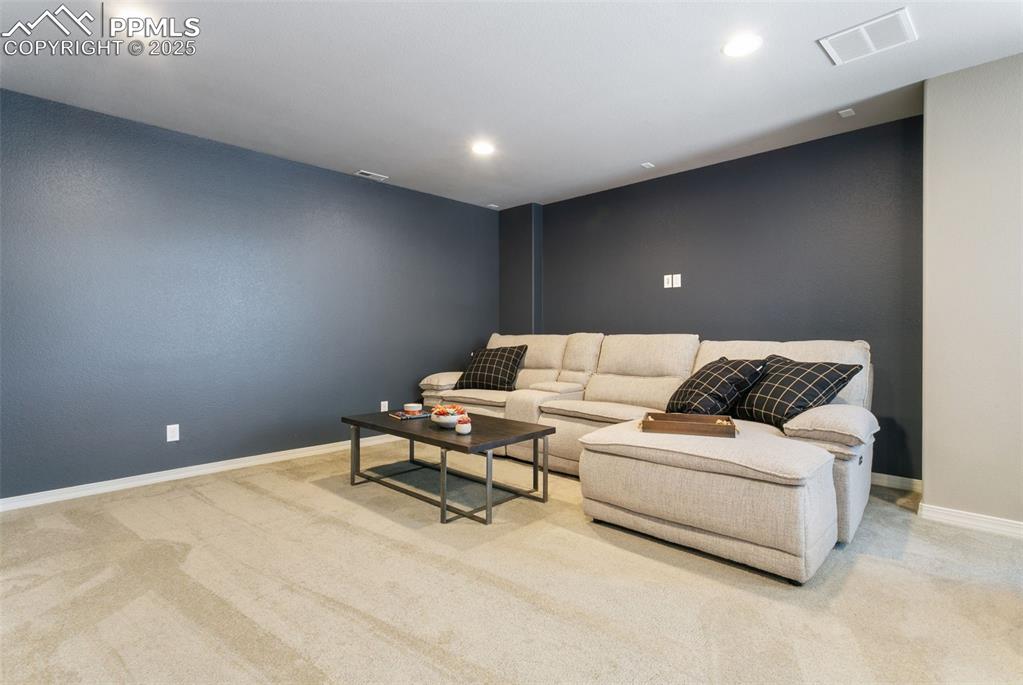 Living area featuring light carpet and recessed lighting