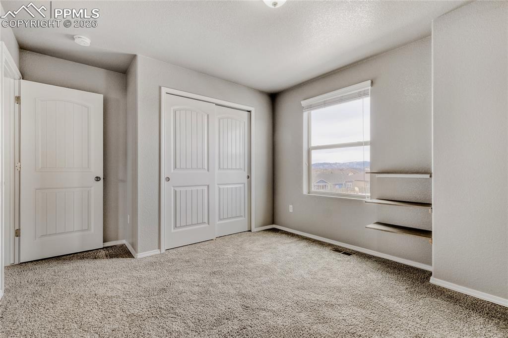 Carpeted bedroom with  closet, shelving, and Mountain View