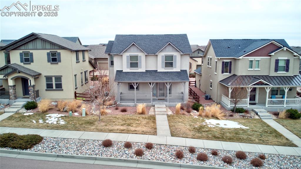 View of front of property with stucco, residential view, covered porch, and front yard