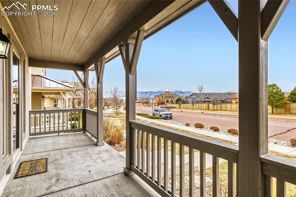 Covered porch featuring a residential view and a mountain view