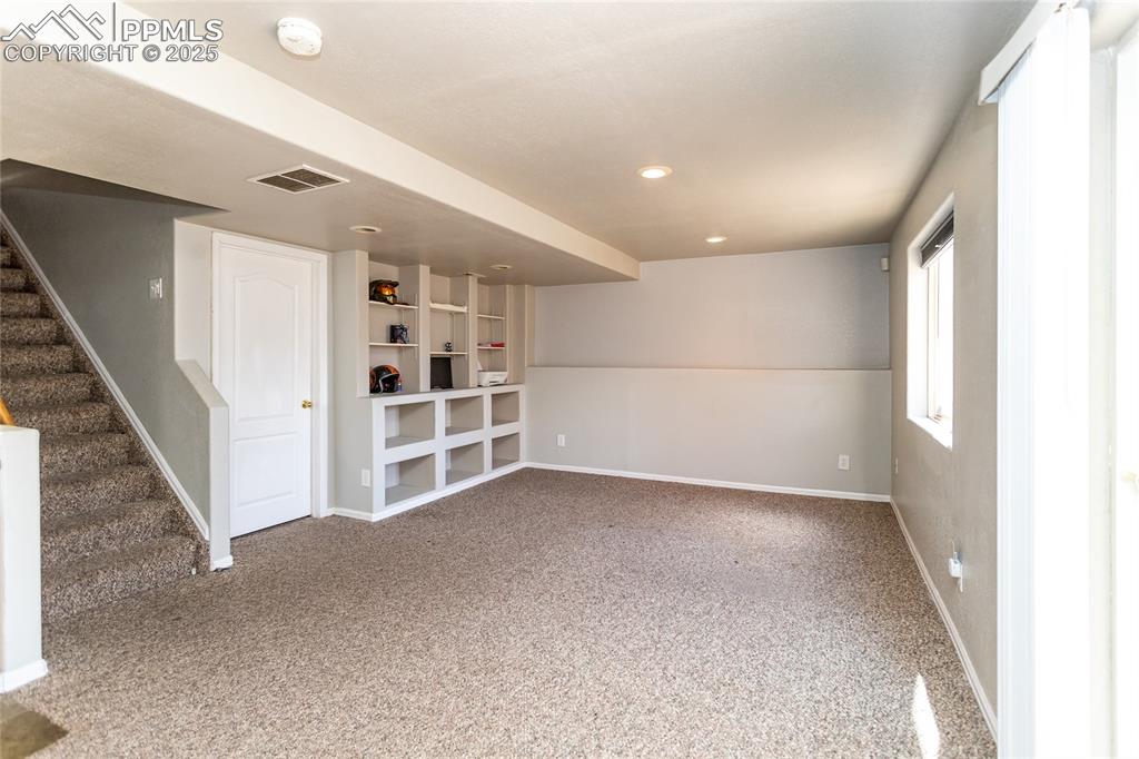 Basement family room with built in shelves.