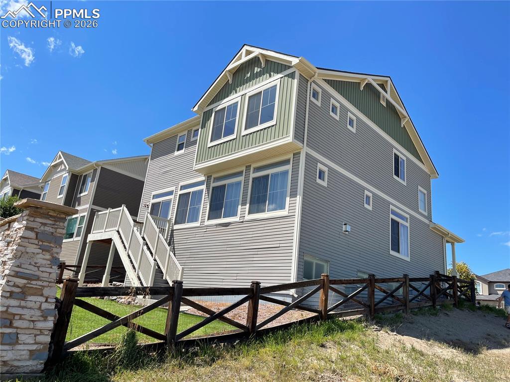 Back of property featuring stairway and board and batten siding
