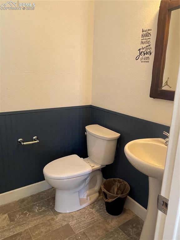 Half bath featuring a wainscoted wall