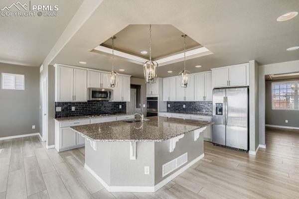 Kitchen with healthy amount of natural light, appliances with stainless steel finishes, light wood-style flooring, and recessed lighting
