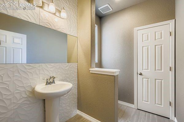 Bathroom featuring a textured wall and baseboards