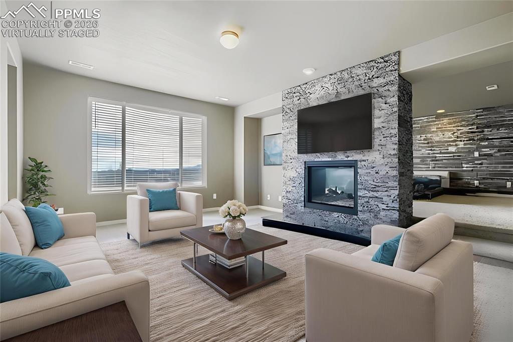 Virtually staged primary bedroom retreat featuring a premium fireplace and baseboards