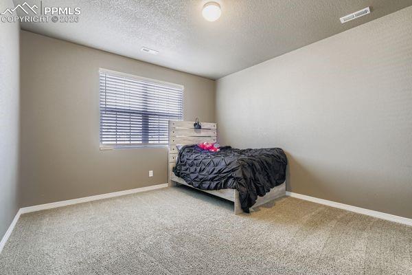 Bedroom featuring carpet floors and a textured ceiling