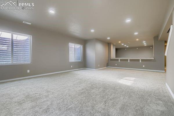 Carpeted spare room featuring baseboards and recessed lighting