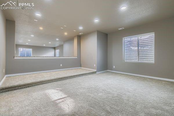 Carpeted empty room featuring plenty of natural light and recessed lighting