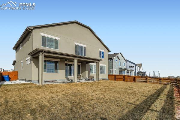 Back of house with a fenced backyard, a patio area, and stucco siding