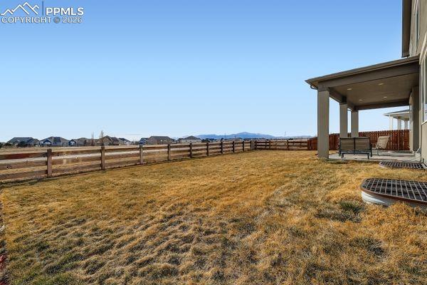 Fenced backyard featuring a patio and a view of countryside