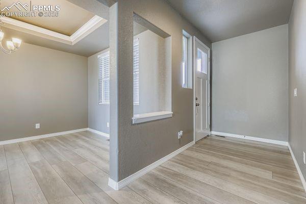 Entryway with light wood finished floors and a chandelier