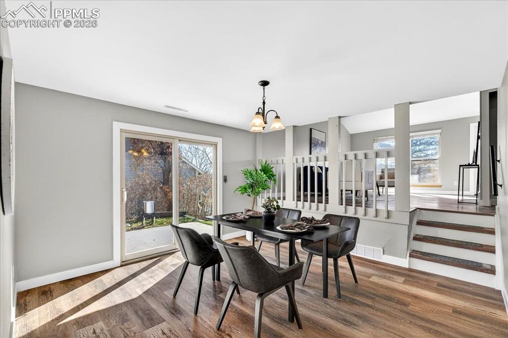 Dining space with wood finished floors and a chandelier