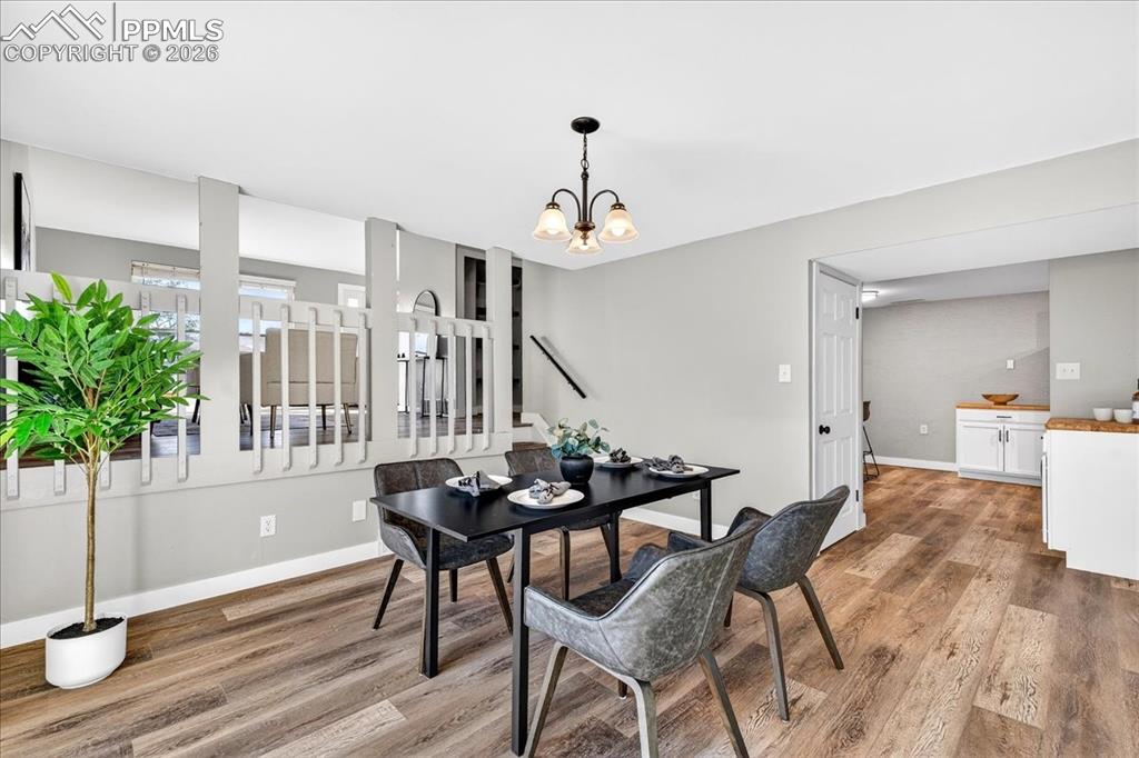 Dining space with light wood-style floors and suspended lighting