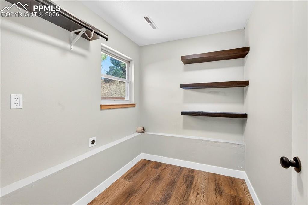 Spare room with dark wood-type flooring and baseboards