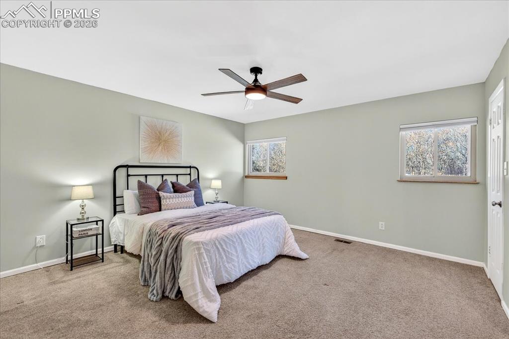 Carpeted bedroom featuring baseboards and a ceiling fan