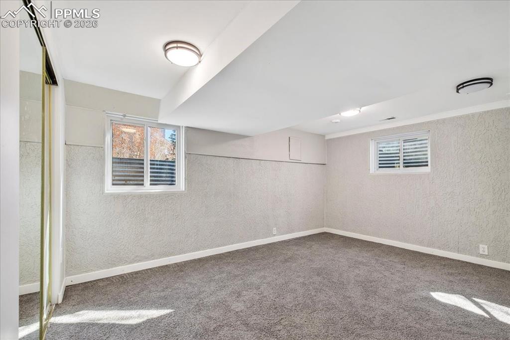 Basement featuring a textured wall, healthy amount of natural light, and carpet
