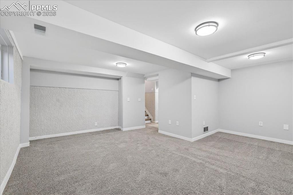 Finished basement featuring baseboards and light carpet