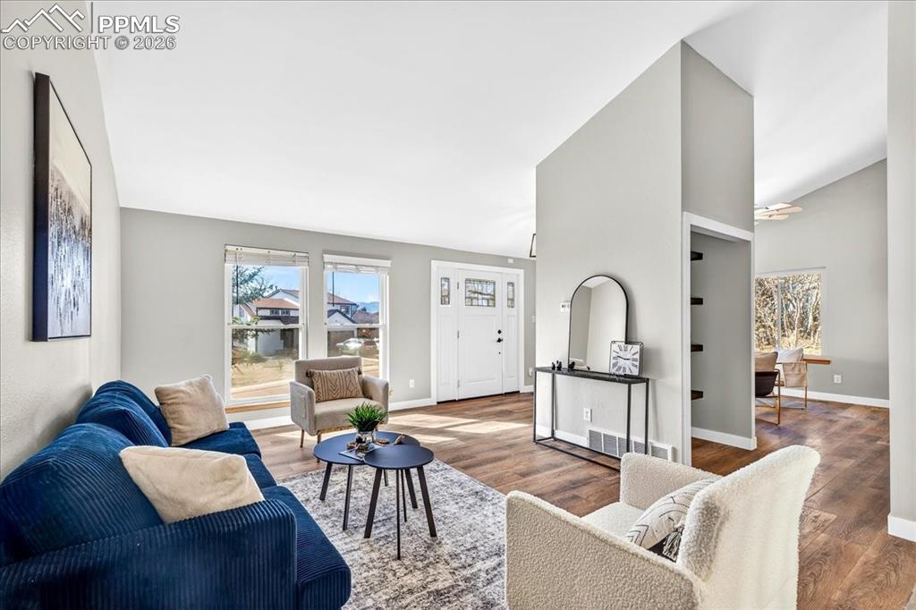 Living area featuring wood finished floors and vaulted ceiling