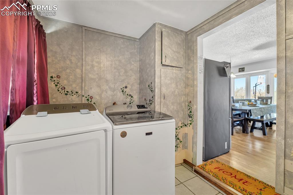 Laundry room with light tile patterned floors and separate washer and dryer