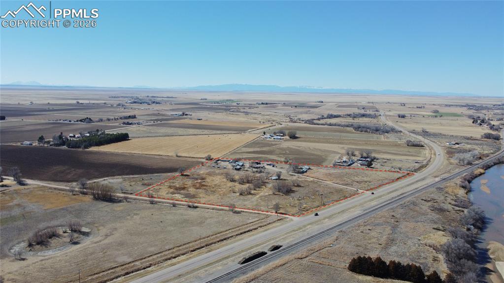 Aerial view of sparsely populated area featuring property parcel outlined and mountains