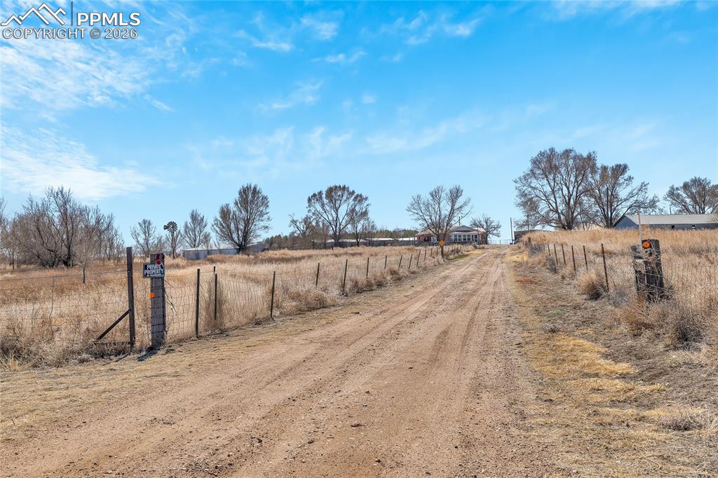 View of dirt / gravel road with a view of rural / pastoral area