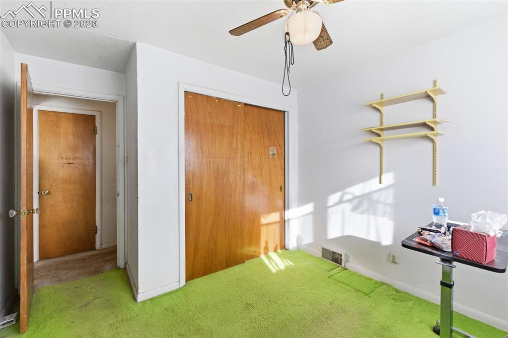 Carpeted bedroom with a closet and ceiling fan