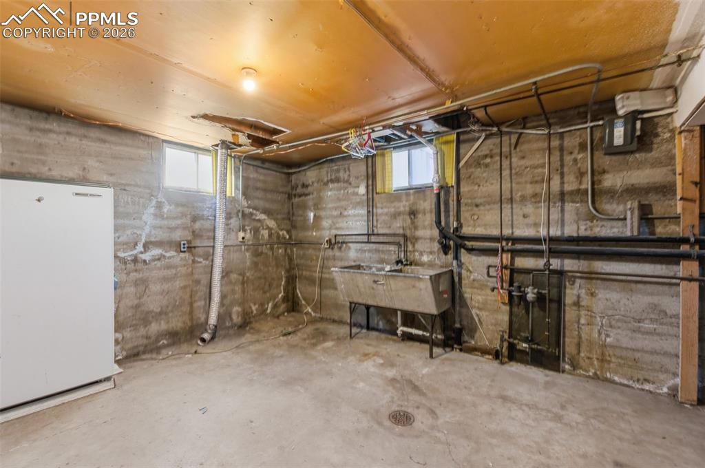 Basement featuring freestanding refrigerator and plenty of natural light