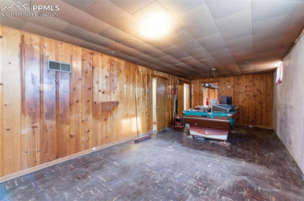 Game room with tile patterned floors, pool table, and wooden walls