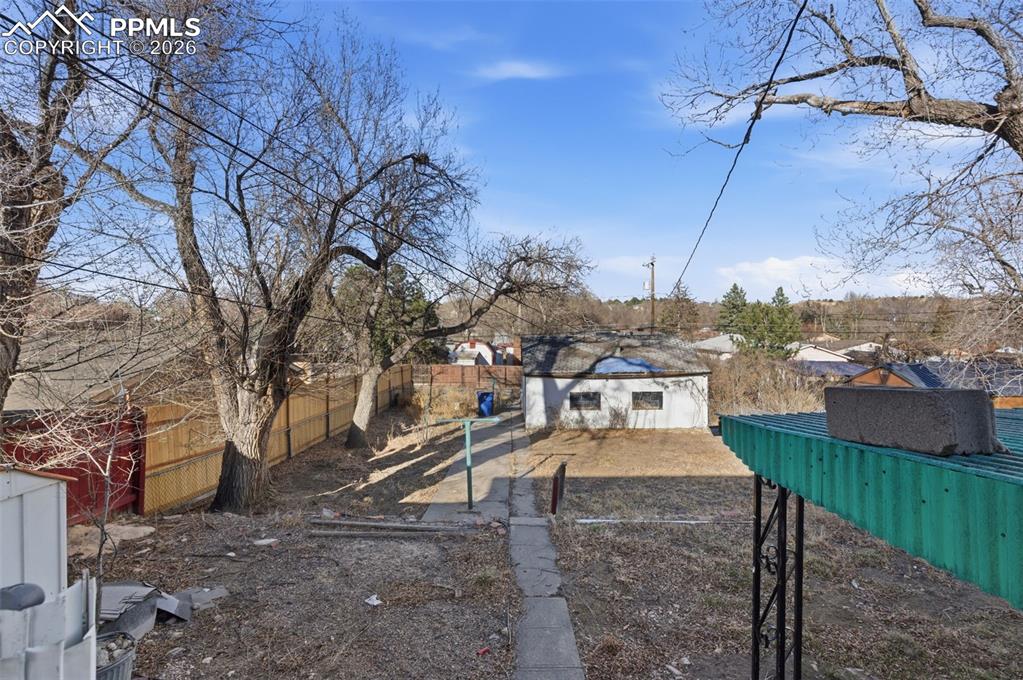 Fenced backyard with an outbuilding