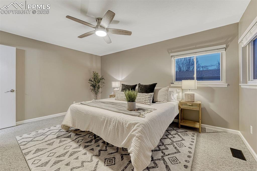 Primary bedroom with ceiling fan is so spacious
