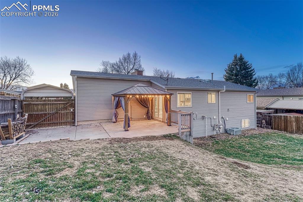 Large patio and big gate at back of carport