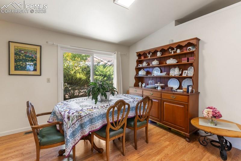 Dining room featuring vaulted ceiling and light wood-style floors