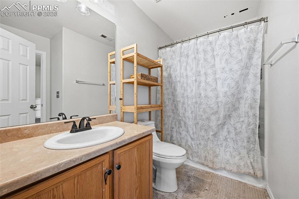 Bathroom featuring vanity and shower / bathtub combination with curtain