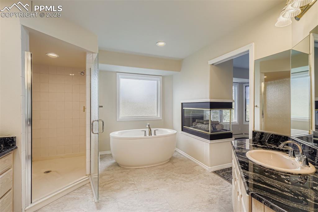Full bath with vanity, a freestanding bath, a freestanding shower, recessed lighting, vinyl flooring, new bath tub (upper level)