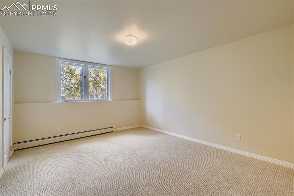 Spare room featuring a baseboard radiator and carpet flooring